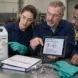 Workers compare a chemical label with safety data sheet information