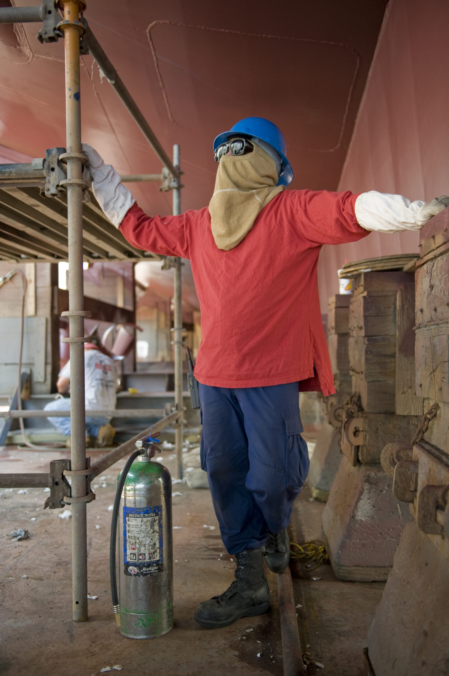 Worker conducting a fire watch during hot work maintenance with a fire extinguisher immediately available