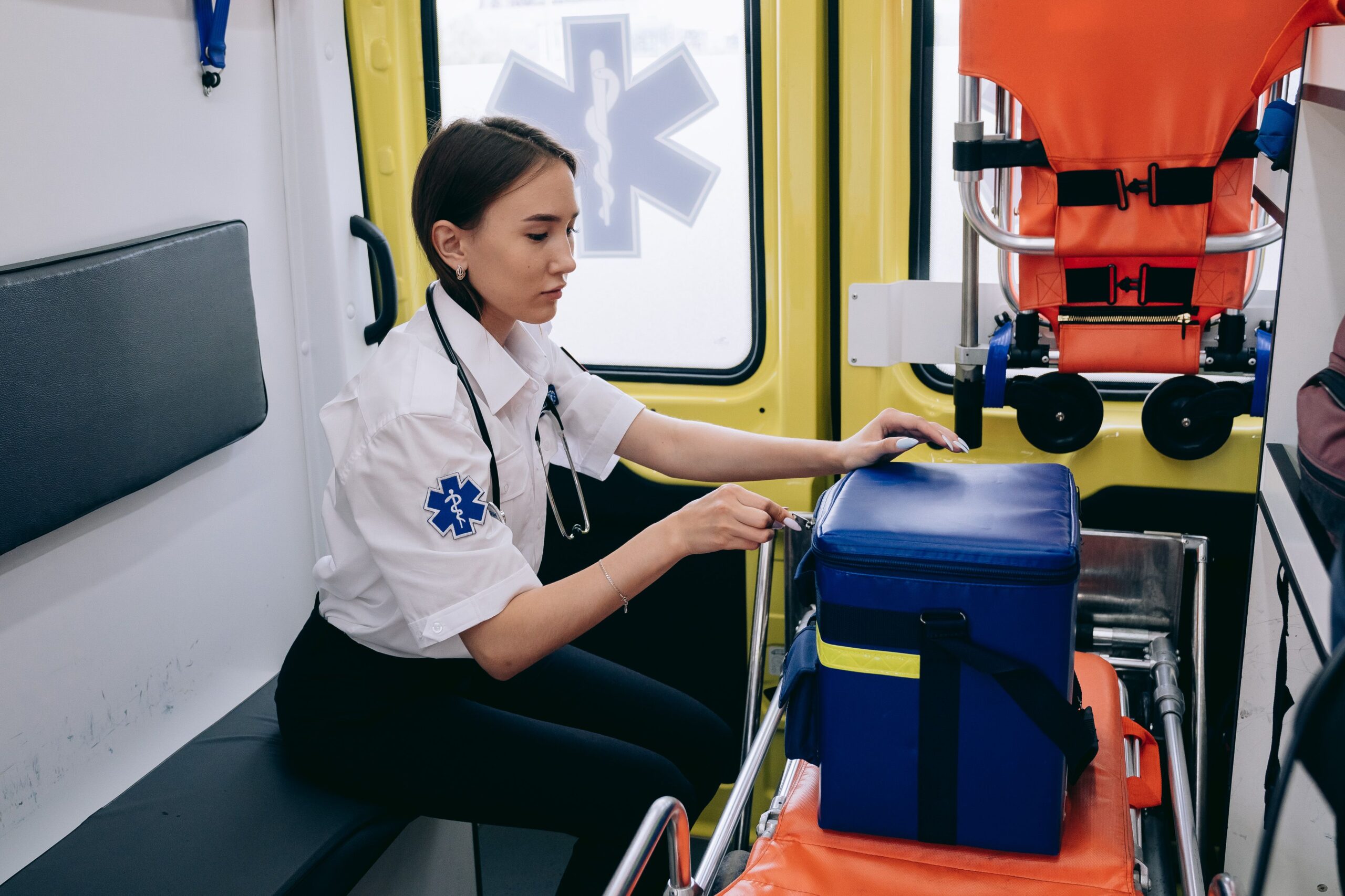 Paramedic preparing emergency medical equipment inside an ambulance
